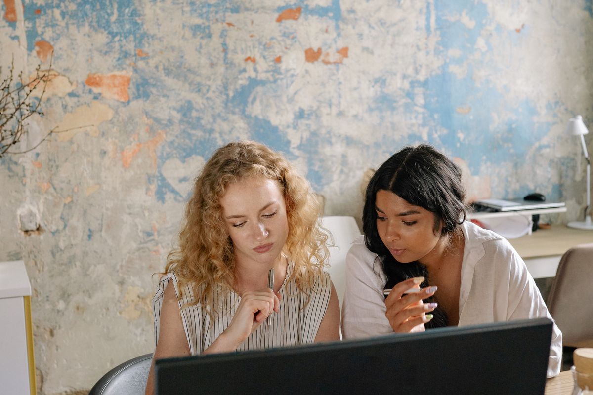 Two colleagues going through work on a laptop